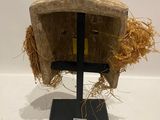 an old helmet on a stand with straw on top of it