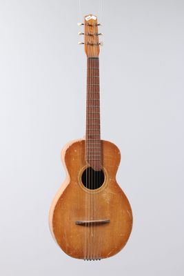 an old wooden guitar hanging from a string on a white background