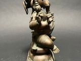 an old bronze statue of a person sitting on top of an elephant