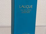 an image of a bottle of perfume sitting on top of a glass table