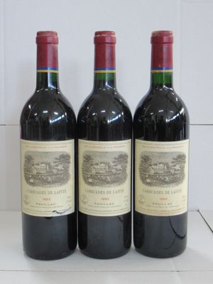 Trois bouteilles de vin rouge sont alignées sur un comptoir