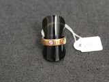 une bague sertie d'une pierre rose, posée sur une table