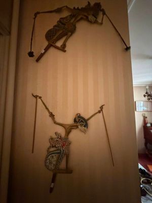 a clock on the wall with a skeleton hanging on it