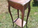 une petite table avec une étagère posée dessus, dans l'herbe