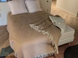 un lit recouvert d'une couverture dans une chambre