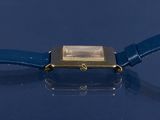 a close up of a wrist watch on a blue surface