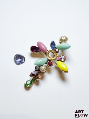 une photo d'une broche ornée d'un bouquet de perles