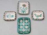 four pieces of pottery with designs on them on a table