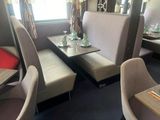 tables and chairs in a restaurant with a large window in the background