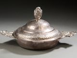 a silver dish with a bird on top of it