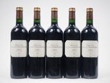 quatre bouteilles de vin sont alignées sur une surface blanche