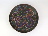 une assiette décorative représentant un dragon sur un fond blanc