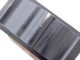 an image of a piece of black soap on a white surface
