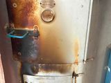 a rusted metal tank sitting on the floor of a bathroom