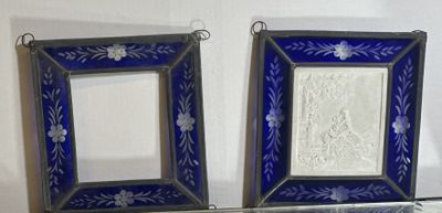 two picture frames hanging on the wall next to each other