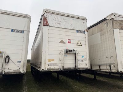 deux semi-remorques blanches garées côte à côte dans un champ
