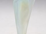 un vase ancien en verre dépoli surmonté d'une figurine