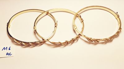 three gold bang bracelets on a white background with a price tag