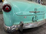 an old car that is parked on the side of the street