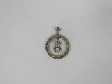 a close up of a silver pendant with a diamond in the center