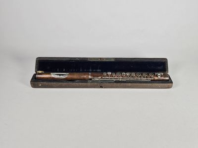 un vieux étui à cigarettes contenant une cigarette, posé sur une surface blanche
