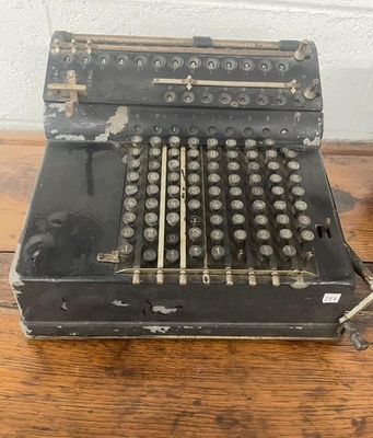 une vieille machine à écrire noire posée sur une table en bois