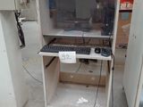 a computer on a cart in a warehouse with a lot of tools