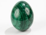 a green marble ball sitting on a white surface