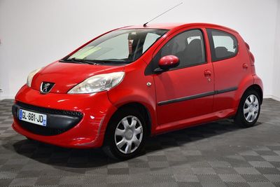 La petite voiture rouge est garée sur le sol à damier.