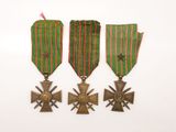 trois médailles et une croix sur fond blanc