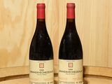 deux bouteilles de vin posées sur un tonneau en bois