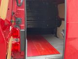 une camionnette rouge avec un tapis rouge à l'arrière