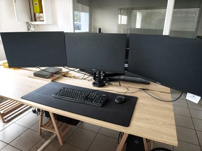 a computer desk with two monitors and a keyboard on it