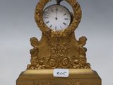 a gold clock sitting on top of a table