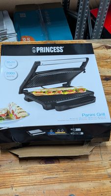 une boîte contenant un appareil à sandwich, posée sur une table en bois