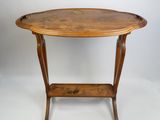 une table de forme ovale avec un plateau et des pieds en bois