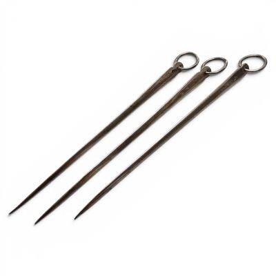 three pairs of metal knitting needles sitting on top of a white surface