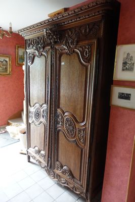 une grande armoire en bois dans le coin d'une pièce