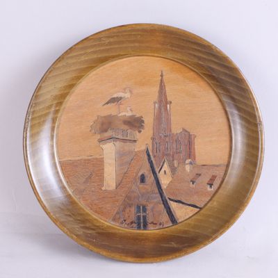 une assiette en bois sur laquelle est représenté un bâtiment