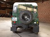 a green and white land rover parked in a garage