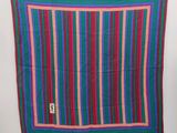 a close up of a colorful striped scarf hanging on a wall