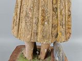 an old statue of a woman holding a basket of flowers
