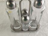 three salt and pepper shakers in a metal holder