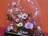 un dôme en verre contenant des fleurs, posé sur une table