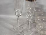 several empty wine glasses are lined up on a white surface
