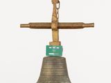 a bell with a wooden cross on top of it