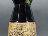 a black vase with a yellow and black design on it