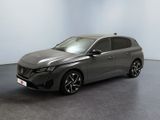 La voiture grise est garée dans une grande pièce au sol noir.