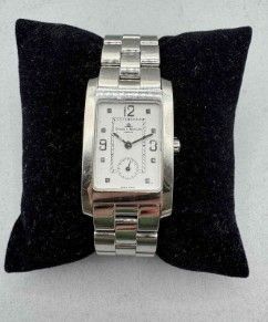 an image of a silver watch on a black cushion on a white surface