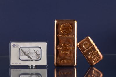 trois types différents de lingots d'or posés sur une table en verre